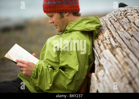 Un homme lit un livre au camp sur la côte perdue, en Californie. Banque D'Images