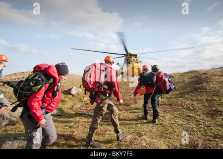 Membres de Langdale Ambleside/chef d'équipe de secours en montagne a secouru les promeneurs à la sécurité, en vue d'un hélicoptère Sea King de la RAF en attente Banque D'Images