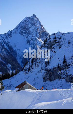 Groupe de randonneurs dans l'avant du chalet de montagne, Grosser Rettenstein en arrière-plan, Brechhorn, Alpes de Kitzbühel, Tyrol, Austr Banque D'Images