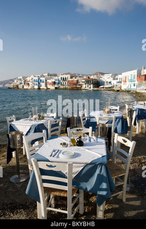 Afficher le long de rue avec restaurants et bars, des moulins à vent en arrière-plan, la Petite Venise, Mykonos-Town, Mykonos, Grèce Banque D'Images