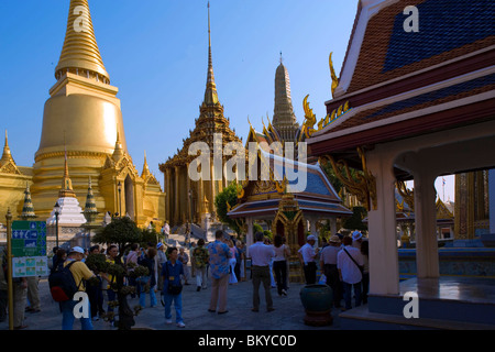 Groupe de touristes visitant le Wat Phra Kaew, le plus important temple bouddhiste de Thaïlande, Phra Sri Rattana Chedi et Phra Mo Banque D'Images