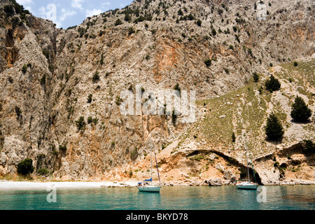 Deux bateaux à voile à la plage près de l'ancrage dans Sisalona Rock Bay, face à l'arrière-plan, l'île de Symi, Pedi, Grèce Banque D'Images