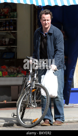 David Cameron sur une bicyclette faisant ses courses dans un magasin situé dans la région de Notting Hill Banque D'Images