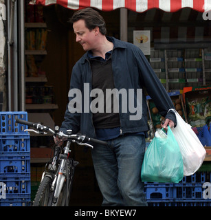 David Cameron sur une bicyclette faisant ses courses dans un magasin situé dans la région de Notting Hill Banque D'Images