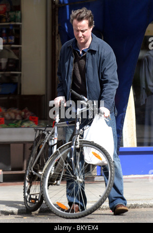 David Cameron sur une bicyclette faisant ses courses dans un magasin situé dans la région de Notting Hill Banque D'Images