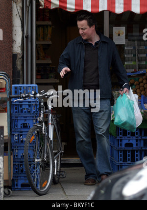 David Cameron sur une bicyclette faisant ses courses dans un magasin situé dans la région de Notting Hill Banque D'Images