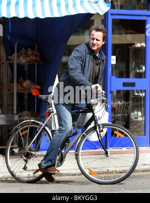 David Cameron sur une bicyclette faisant ses courses dans un magasin situé dans la région de Notting Hill Banque D'Images