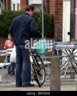 David Cameron sur une bicyclette faisant ses courses dans un magasin situé dans la région de Notting Hill Banque D'Images