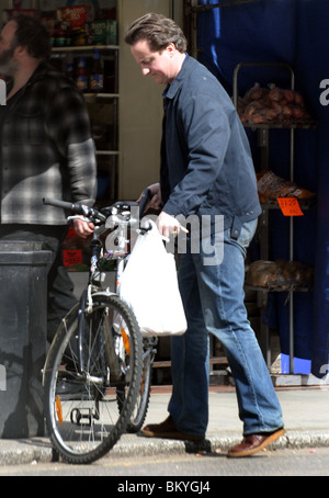 David Cameron sur une bicyclette faisant ses courses dans un magasin situé dans la région de Notting Hill Banque D'Images