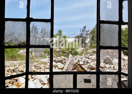 Vue d'un tas de gravats de la fenêtres brisées d'une usine partiellement démoli. Banque D'Images