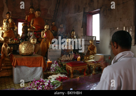 Un homme dans la prière au cours de Wai Kru Journée à Wat Phra Bang, un temple bouddhiste en Thaïlande où les moines dévots de tatouage. Banque D'Images