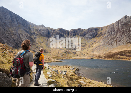 Deux hommes millénaire les randonneurs par Llyn Idwal à au Devil's Kitchen en montagnes de Snowdonia National Park. Le CWM Idwal Ogwen North Wales Royaume-uni Grande-Bretagne Banque D'Images