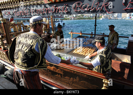 La célèbre vente de bateaux du poisson grillé sandwiches, connu localement comme Balik Ekmek à harbourside Eminönü à Istanbul, Turquie Banque D'Images