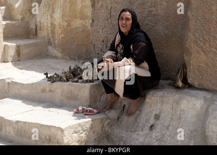 Femme égyptienne souvenir vente parmi les pierres des grandes pyramides en Egypte Banque D'Images