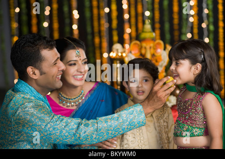 L'alimentation de l'homme des bonbons à ses enfants sur le Diwali Banque D'Images