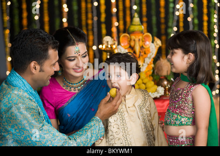 L'alimentation de l'homme des bonbons à ses enfants sur le Diwali Banque D'Images