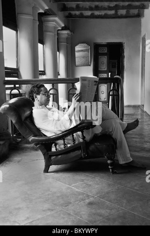 L'homme de lire le journal dans le balcon Banque D'Images