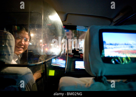 Shanghai Taxi, femme chauffeur de taxi, un bouclier de protection, écran de télévision, heureux, riant, heureux, le bonheur Banque D'Images