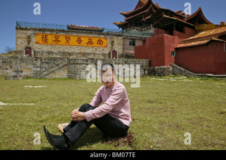 Jeune femme en face de Huazong touristique monastère, 3077 mètres d'altitude, sommet d'or, sommet de l'Emei Shan, son monde Banque D'Images