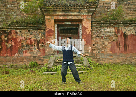 Mouvements de Taichi Master démontre, en face de sa maison ancienne en dessous du pic, Wudang Shan, la montagne taoïste, province de Hubei, Wu Banque D'Images