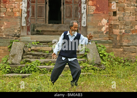 Mouvements de Taichi Master démontre, en face de sa maison ancienne en dessous du pic, Wudang Shan, la montagne taoïste, province de Hubei, Wu Banque D'Images