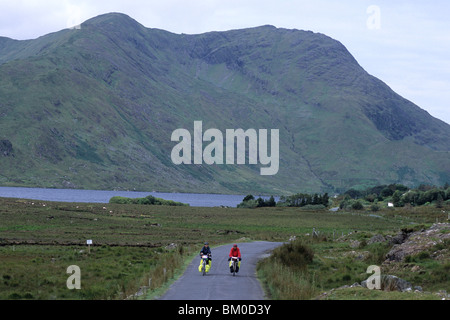 Les cyclistes sur route du Connemara, près de Lough Fee, comté de Galway, Irlande Banque D'Images