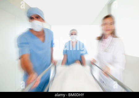 Les médecins de pousser un patient sur une civière à l'hôpital dans un couloir de l'hôpital Banque D'Images