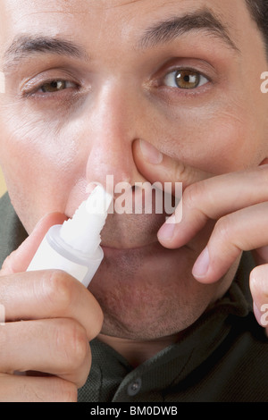 L'homme à l'aide de spray nasal Banque D'Images