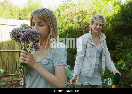 Young woman smelling flowers in garden Banque D'Images