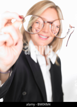 Woman holding verres en face d'elle Banque D'Images