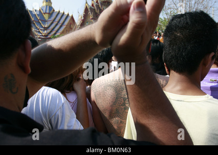 Un homme dans la prière au cours de Wai Kru Journée à Wat Phra Bang, un temple bouddhiste en Thaïlande où les moines dévots de tatouage. Banque D'Images