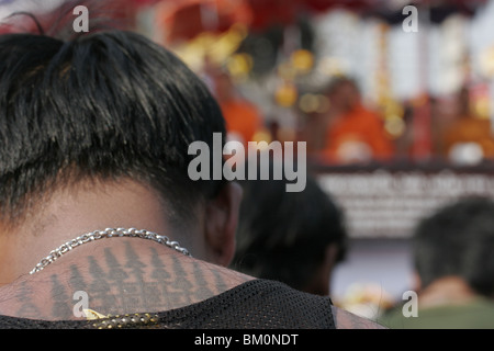 Un homme dans la prière au cours de Wai Kru Journée à Wat Phra Bang, un temple bouddhiste en Thaïlande où les moines dévots de tatouage. Banque D'Images