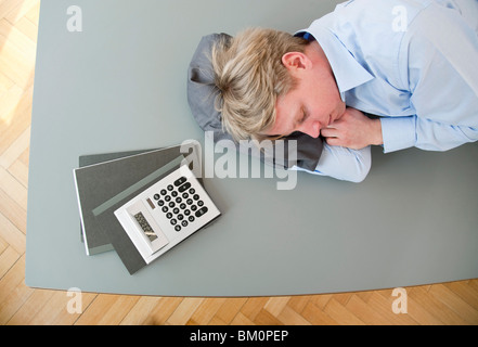 Businessman sleeping on conference table Banque D'Images