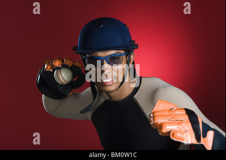 Wicket keeper jetant une balle de cricket Banque D'Images