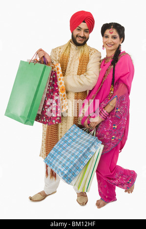 Portrait d'un Sikh couple carrying shopping bags Banque D'Images