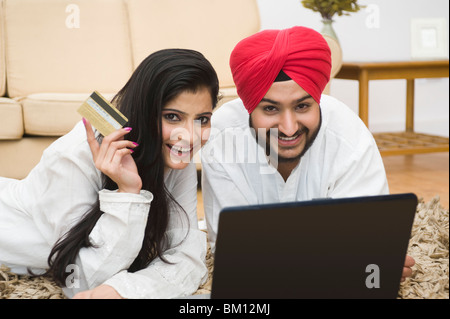 Couple Sikh d'une carte de crédit et de travail sur un ordinateur portable Banque D'Images