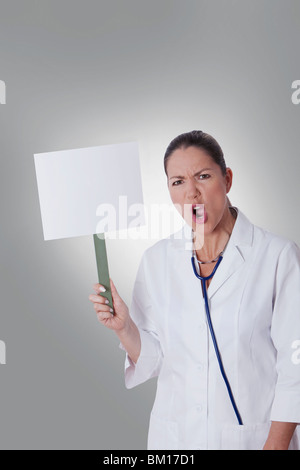 Female doctor holding a blank placard Banque D'Images