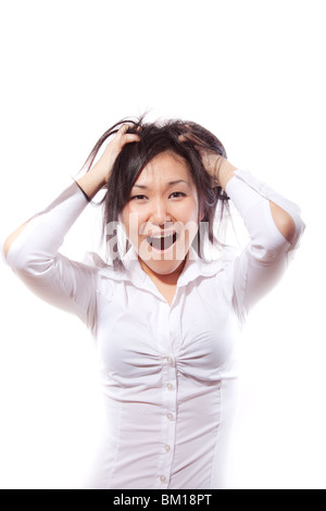 La jolie jeune fille dans une chemise blanche larmes sur elle-même les cheveux avec shout Banque D'Images