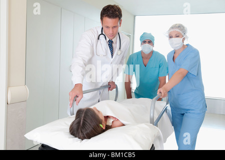 Les médecins de pousser un patient sur une civière à l'hôpital dans un couloir de l'hôpital Banque D'Images