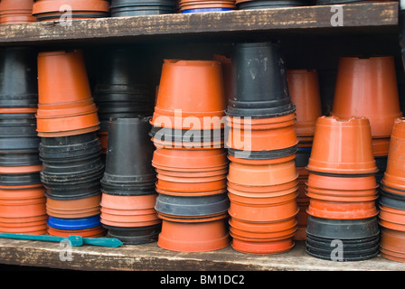 Des piles de pots en plastique stockés sur des étagères prêt pour l'utilisation dans le jardin Banque D'Images