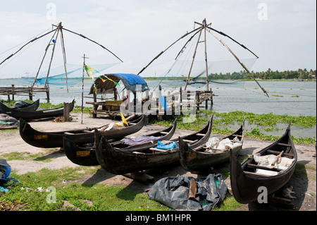 Des barques de pêche échoués près des filets de pêche chinois à Cochin, Inde Banque D'Images