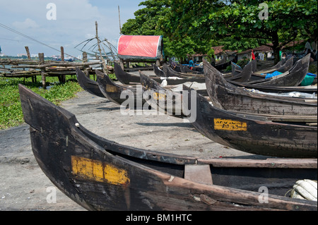 Des barques de pêche échoués près des filets de pêche chinois à Cochin, Inde Banque D'Images