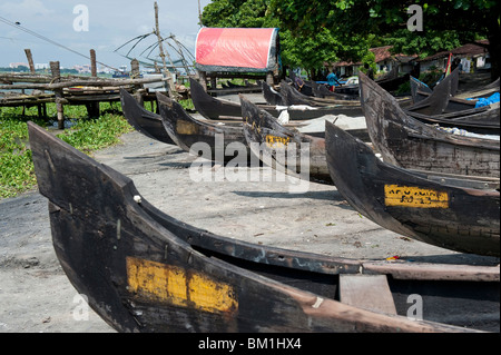 Des barques de pêche échoués près des filets de pêche chinois à Cochin, Inde Banque D'Images