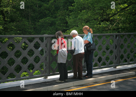 Trois touristes à la dame sur le pont parapet dans la gorge de la rivière au Pont du Diable, Ceredigion, pays de Galles, Royaume-Uni Banque D'Images