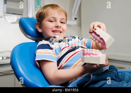 Portrait of a Boy holding a mis des prothèses dentaires Banque D'Images