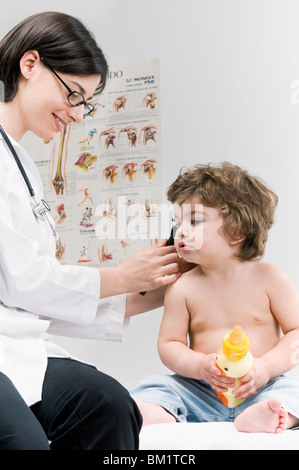 Femme Médecin examinant un baby boy's ear avec un otoscope Banque D'Images