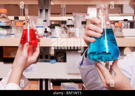 Doctors holding fioles coniques dans un laboratoire Banque D'Images