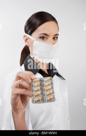 Portrait d'une femme médecin montrant une plaquette de gélules Banque D'Images