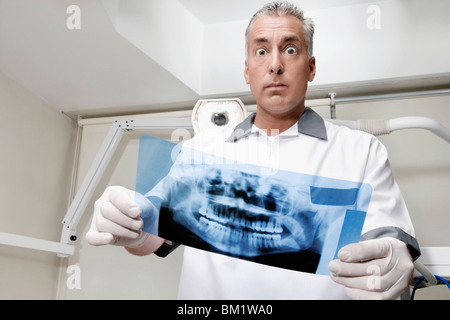 Dentiste l'examen d'une X-Ray report Banque D'Images