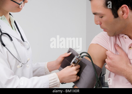 Femme médecin contrôle la pression artérielle de l'homme Banque D'Images